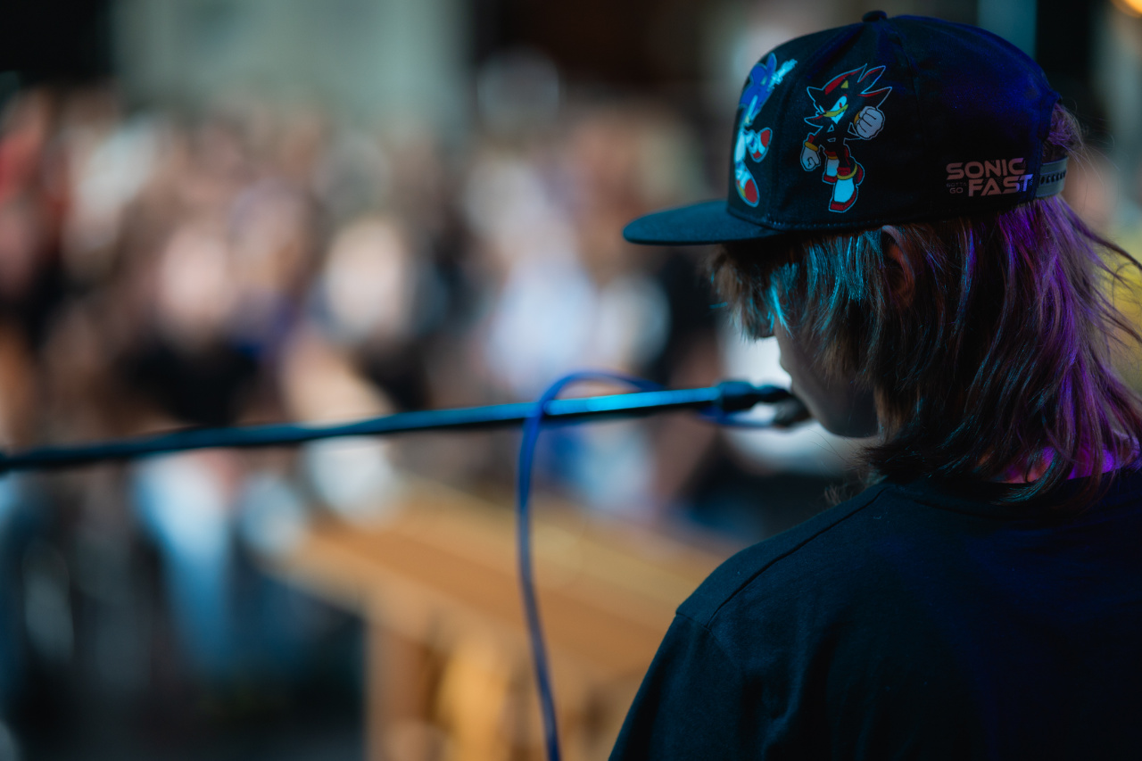muzikant kijkt vanaf het podium naar het publiek, terwijl hij zingt in de microfoon.